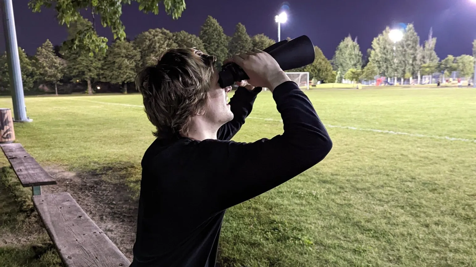 xQc using a pair of binoculars and looking into the sky, from a Tweet where he said "looking for who asked"